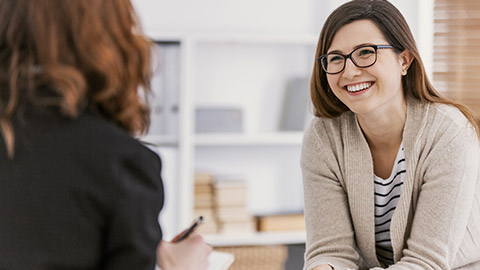 Happy woman during successful psychotherapy with counselor at clinic