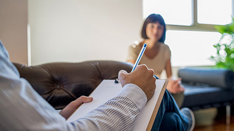 Psychologist taking notes during therapy session