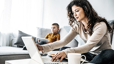 Woman working with a child beside her