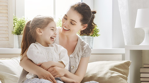 Mother and her daughter child girl playing and hugging