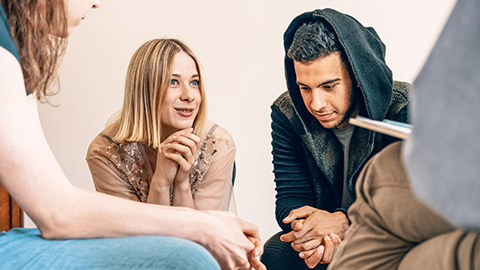 teenagers sitting together and smiling during a support meeting