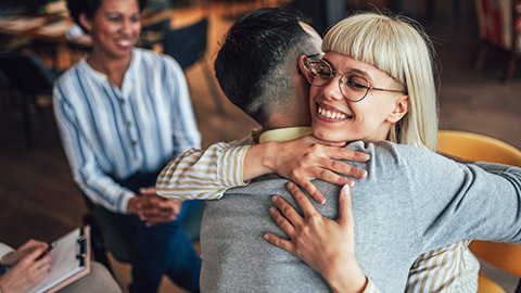 Support group patients hug each other during the therapy session