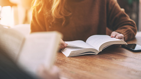 Group of people sitting and enjoyed reading books together on wooden table