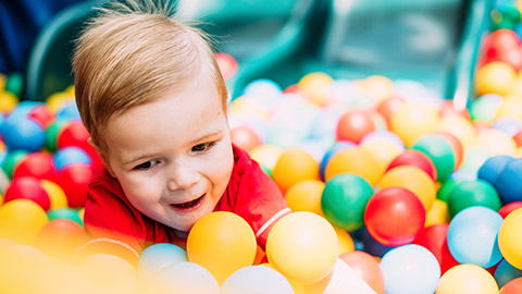 A close view of a kid playing in a ball pit