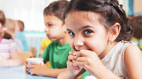 A small child eating food at a childcare facility