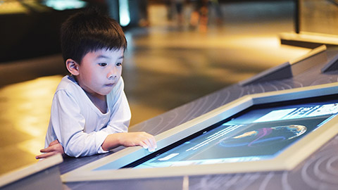 A young child interacting with an exhibit at a museum