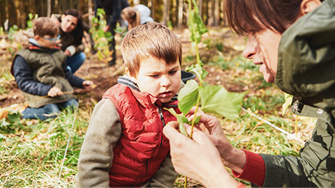 A parent interacting with a child in an outdoor environment