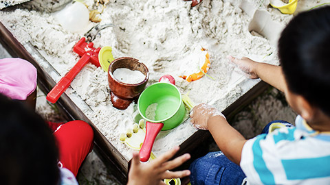 Children engaged in creative play in a sand pit