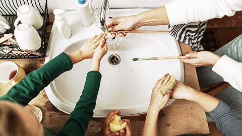 An art class students and teacher washing hands and brushes