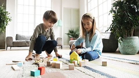 A little boy and a girl blaying with blocks