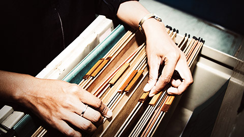 A person arranging files in the cabinet