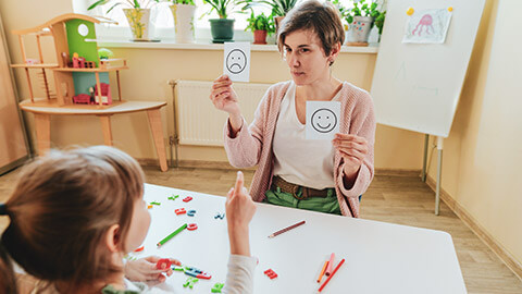 A childcare worker doing an activity with a child