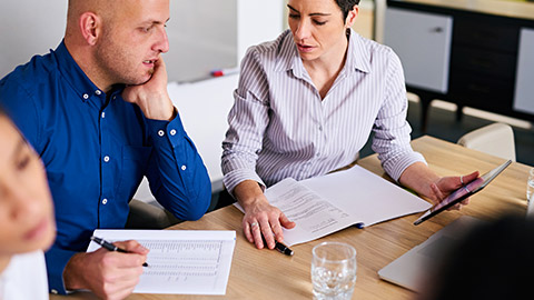 2 coworkers discussing policy changes in a meeting