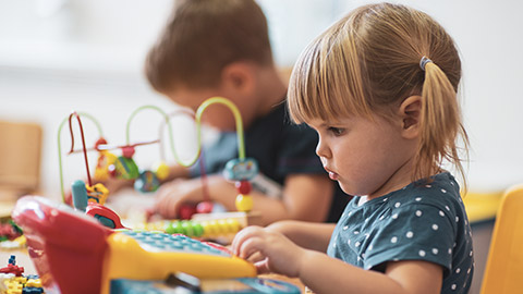 A young child concentrating on playing with a toy