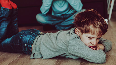 An unhappy child laying on the floor throwing a tantrum