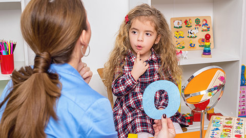 A speech therapist working with a child