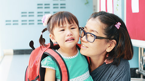 A crying child being consoled by her mother