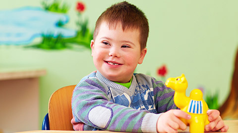 A child enjoying playing at a table with a toy