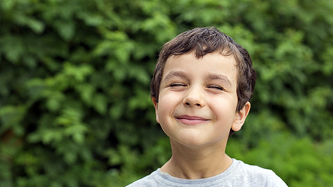 Cute boy smiling while eyes closed