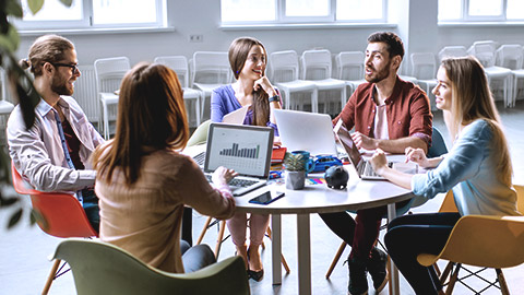 Young co-workers discussing over desk table