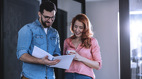 Happy business persons working together while looking at a folder