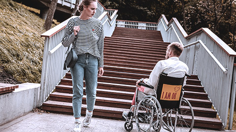 Woman passing a man on wheelchair