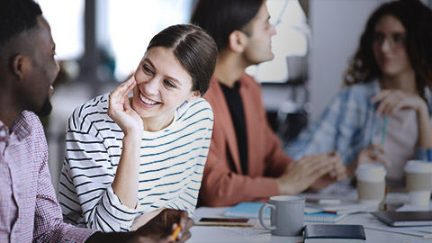 Woman smiling at co-worker while talking