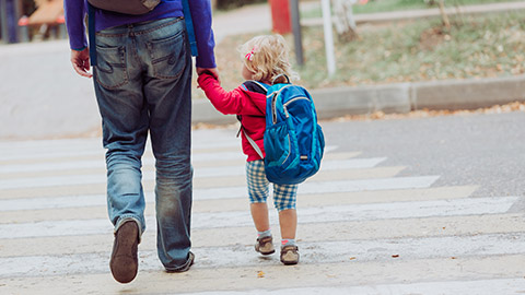 A father walking his child to daycare