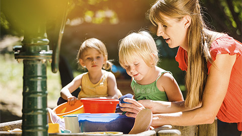 Kindergarten children and teacher playing together