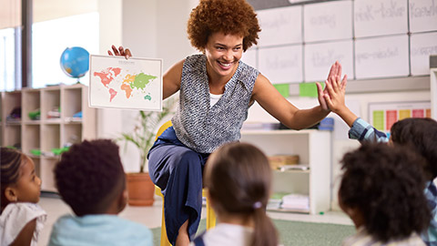 Multi-Cultural Elementary School Pupils With Female Teacher In Geography Class At School