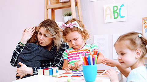 Young educator embrace and calm down crying boy in kindergarten