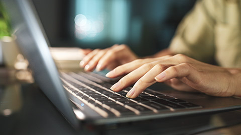 A close view of a person typing on a laptop