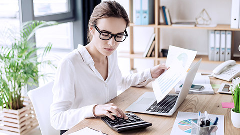 woman making report using calculator