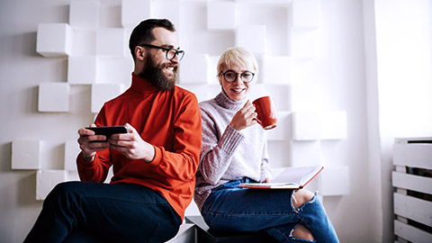 bearded man happily talking with woman with coffee