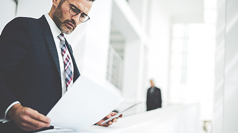 A suited man reading a financial report