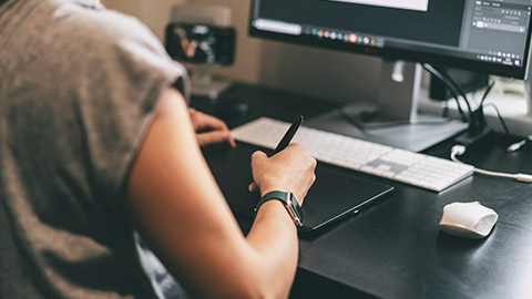 Over-the-shoulder view of a designer working on a desktop computer