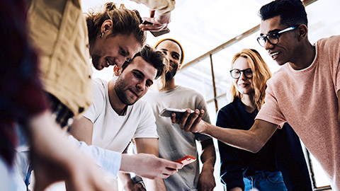 team brainstorming while holding phone