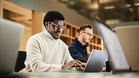 Portrait of Enthusiastic Black Man Turning on his Laptop and Starting his Work Day at the Office