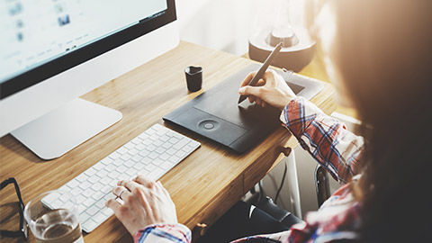 Young hipster graphic designer woman using digital graphic tablet while working at modern office,