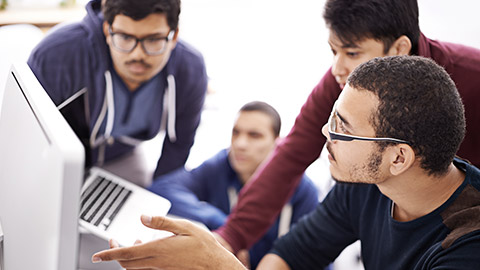 Collaborative coding. Shot of a group of colleagues working together with a computer in an office.