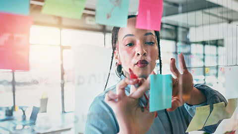 A designer writing on a post-it note