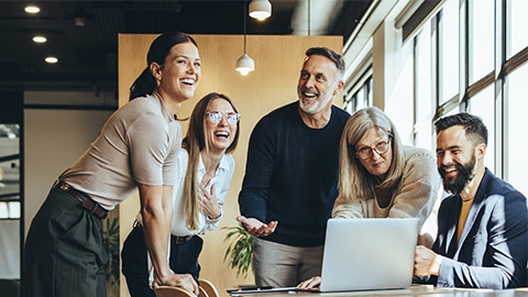 Happy businesspeople laughing while collaborating on a new project in an office