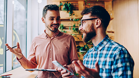 Successful male startuppers discussing plan together for work smiling and gesturing