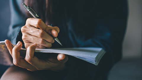 A close view of a person writing on a notebook