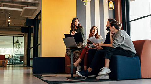 A group of coworkers discussing a project in an office