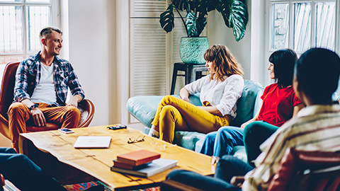 A group of coworkers sitting in a room discussing a project