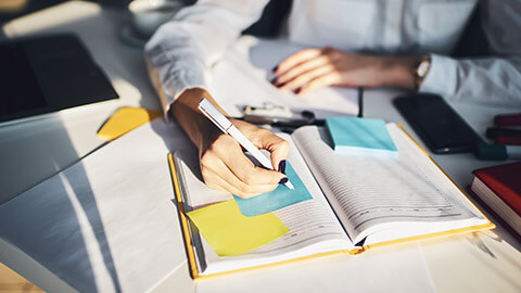 A close view of a person writing notes before a meeting