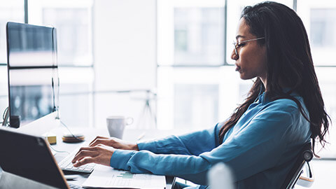 A young professional using multiple devices in an office