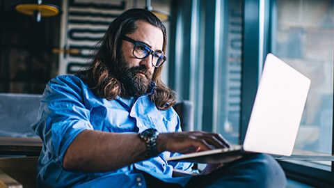 A project manager sending an email on a laptop