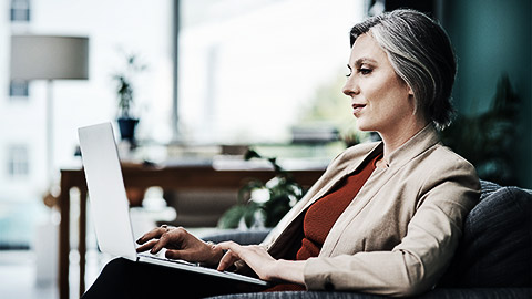 A person using a laptop in a stylish cafe chair